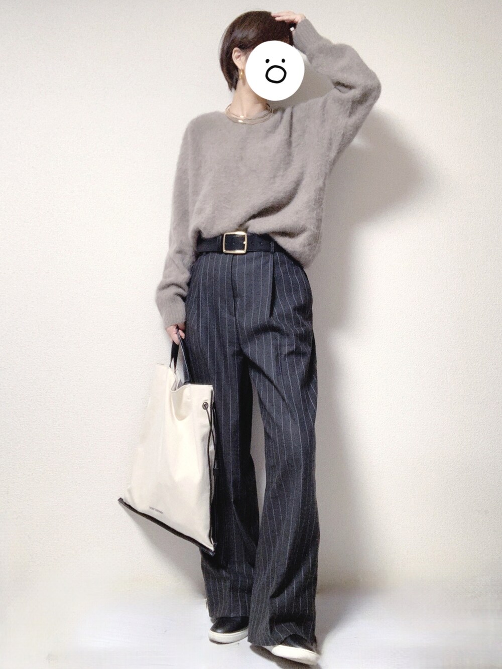 ブラック系のスリッポン、グレー系のスラックス、ブラック系のトートバッグを着用したレディースの冬コーディネートの2枚目の写真