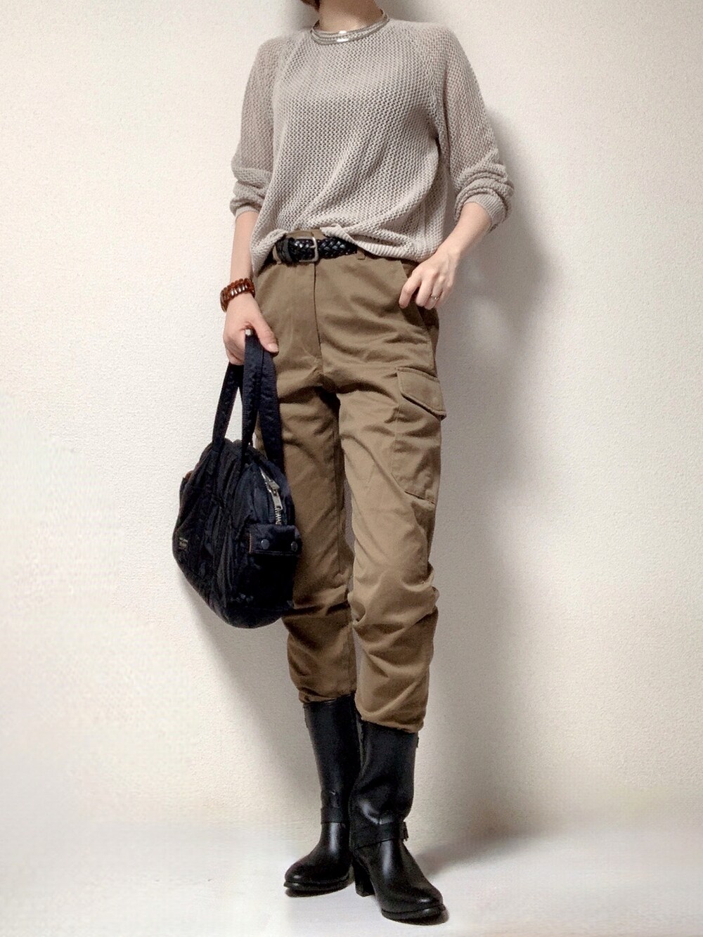 ブラウン系のカーゴパンツ、ブラック系のブーツ、ブラック系のボストンバッグを着用したレディースの秋コーディネートの2枚目の写真