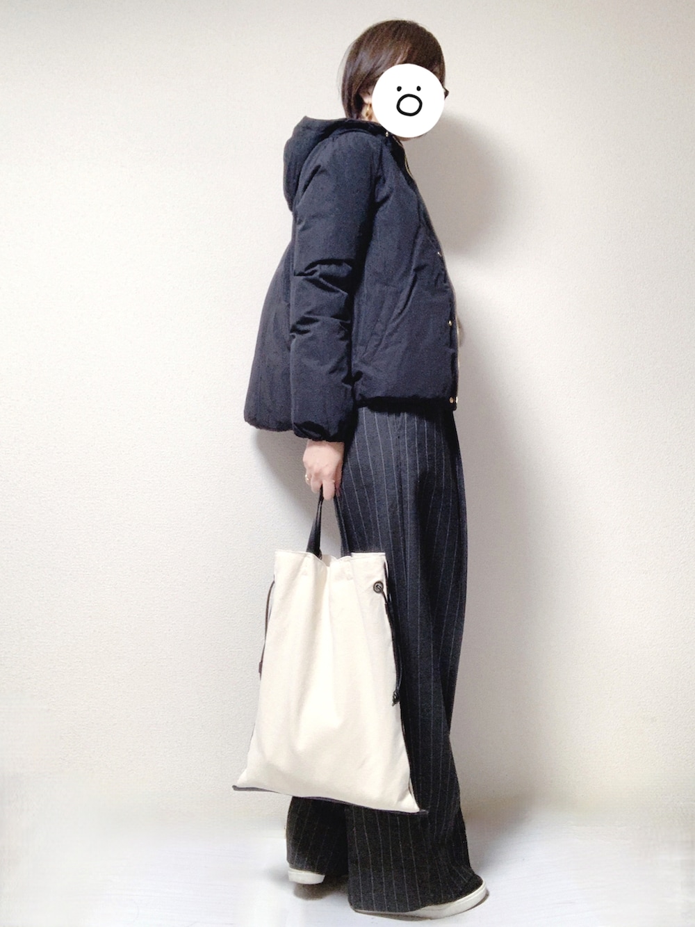 ブラック系のスリッポン、グレー系のスラックス、ブラック系のトートバッグを着用したレディースの冬コーディネートの3枚目の写真