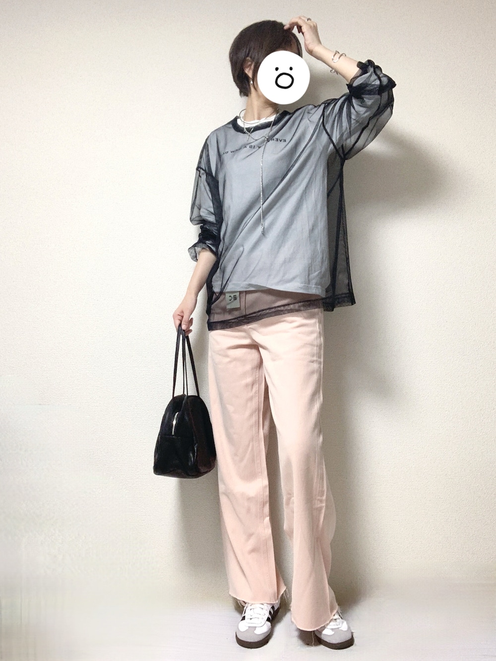 ホワイト系のスニーカー、ピンク系のデニムパンツ、ブラック系のトートバッグを着用したレディースの春コーディネートの2枚目の写真