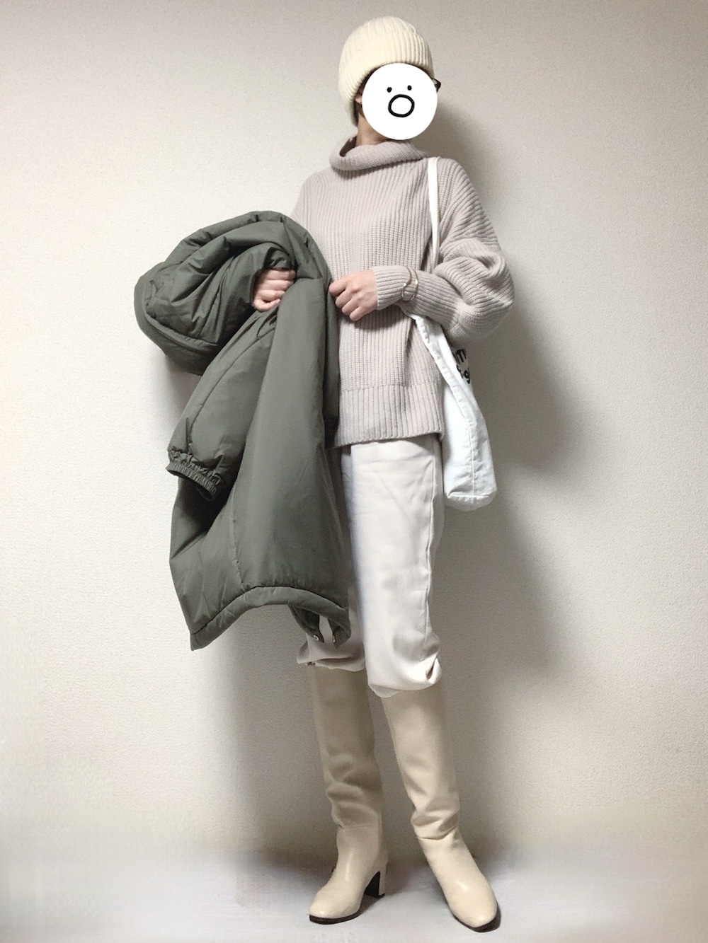 ホワイト系のブーツ、ホワイト系のトートバッグ、ベージュ系のニット/セーターを着用したレディースの冬コーディネートの2枚目の写真