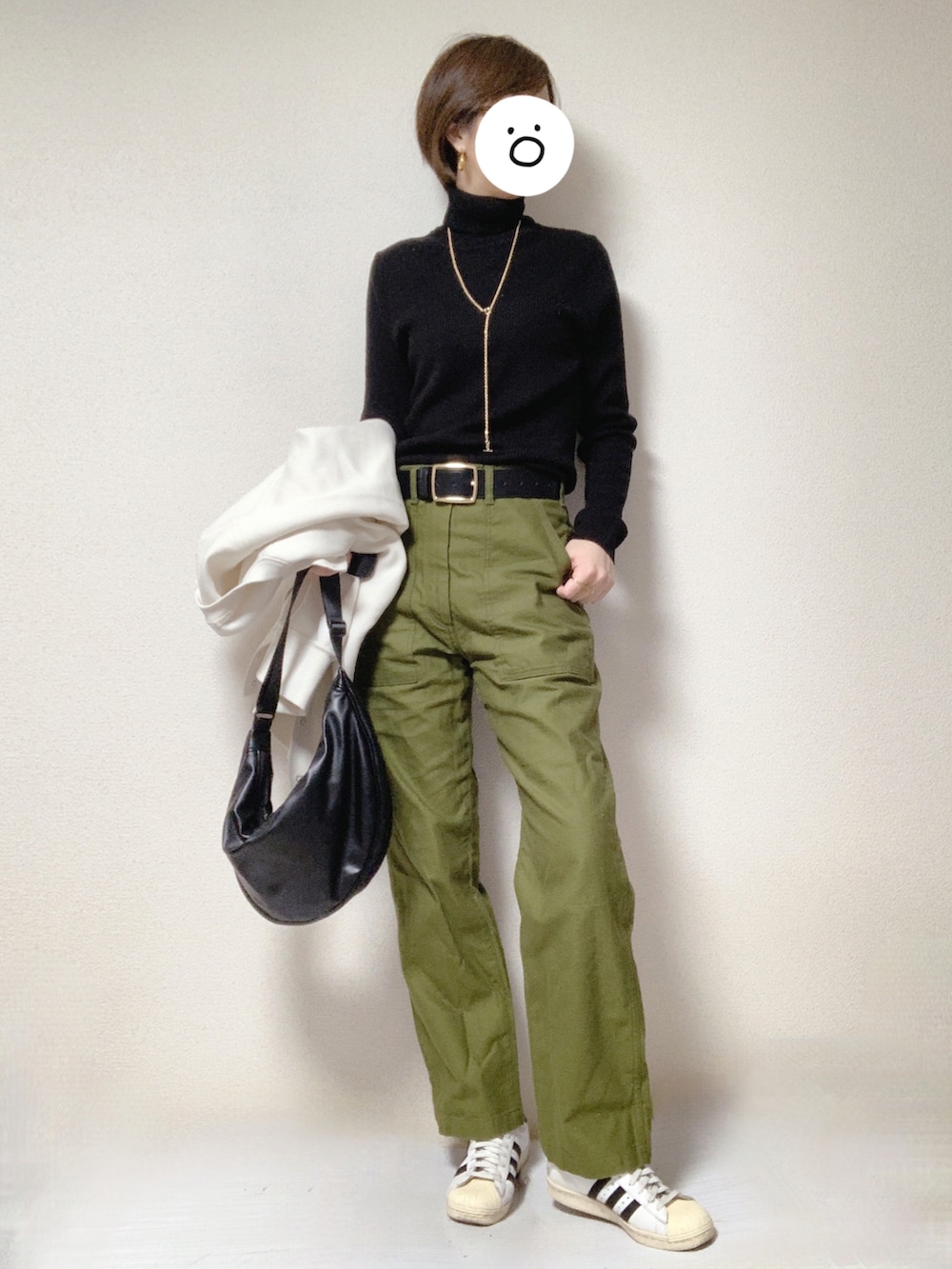 ホワイト系のスニーカー、グリーン系のその他パンツ、ブラック系のショルダーバッグを着用したレディースの冬コーディネートの2枚目の写真