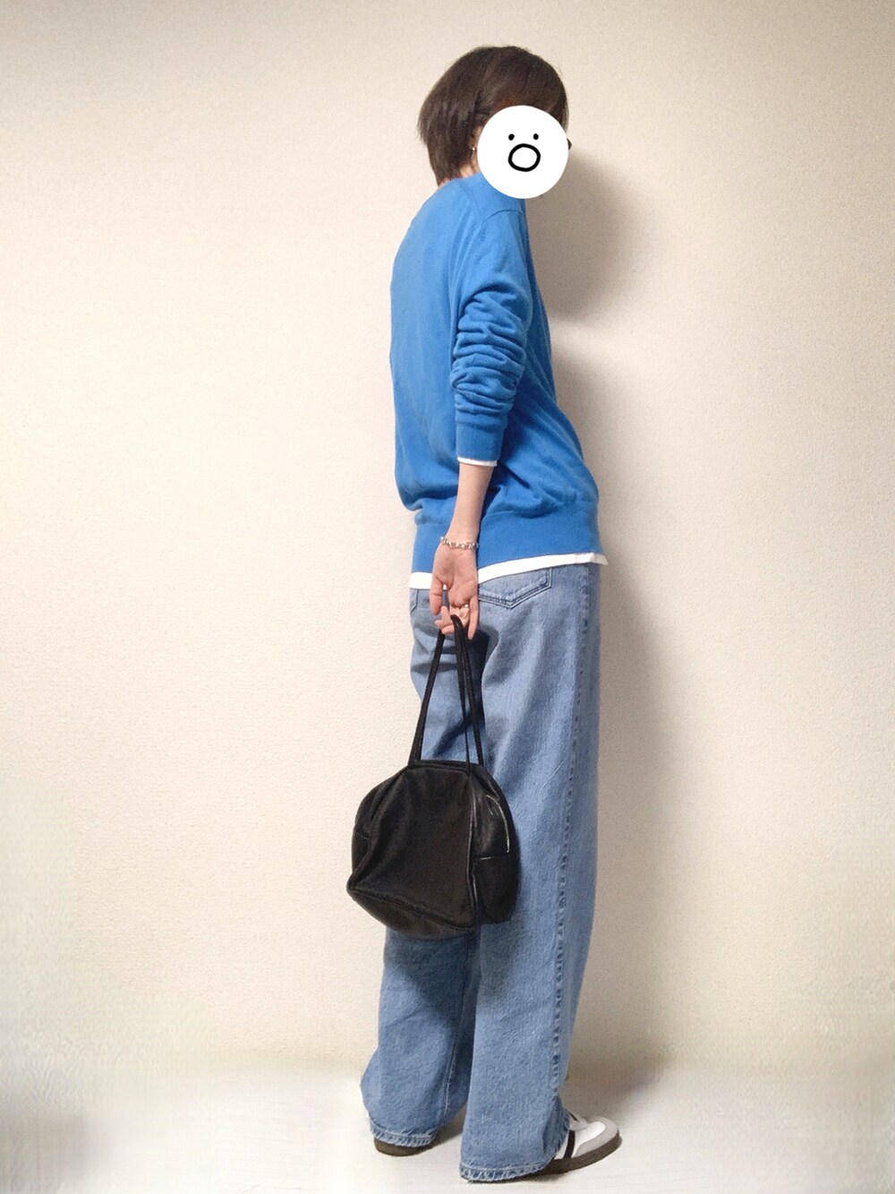 ホワイト系のスニーカー、ブルー系のデニムパンツ、ブラック系のトートバッグを着用したレディースの春コーディネートの2枚目の写真