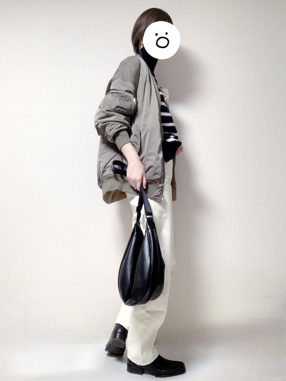 ブラック系のブーツ、ブラック系のショルダーバッグ、ホワイト系のデニムパンツを着用したレディースの冬コーディネートの2枚目の写真