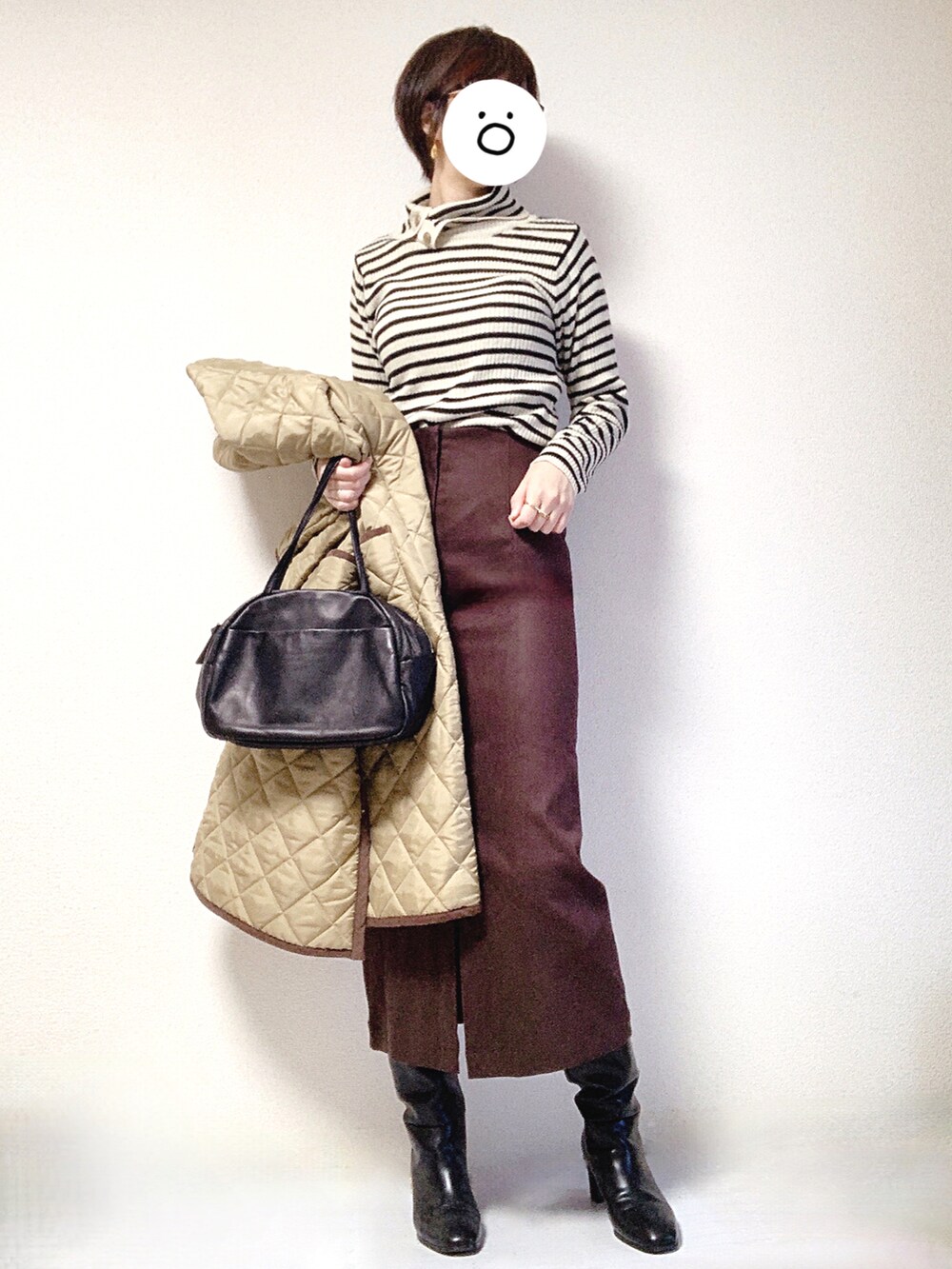 ブラック系のブーツ、ブラック系のトートバッグ、ベージュ系のその他アウターを着用したレディースの冬コーディネートの2枚目の写真