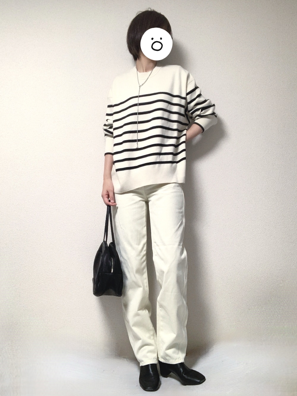 ブラック系のブーツ、ブラック系のトートバッグ、ホワイト系のデニムパンツを着用したレディースの冬コーディネートの2枚目の写真