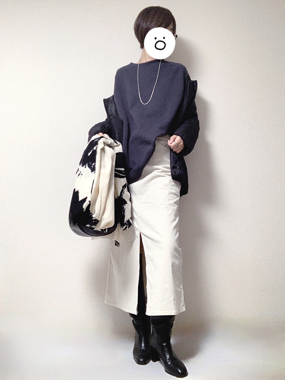 ブラック系のブーツ、ホワイト系のスカート、ブラック系のショルダーバッグを着用したレディースの秋コーディネートの2枚目の写真