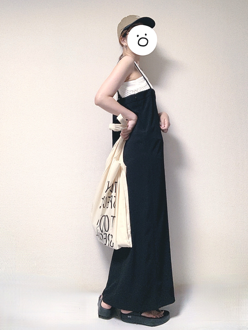 ブラック系のワンピース、ホワイト系のタンクトップ、ベージュ系のエコバッグ/サブバッグを着用したレディースの夏コーディネートの2枚目の写真