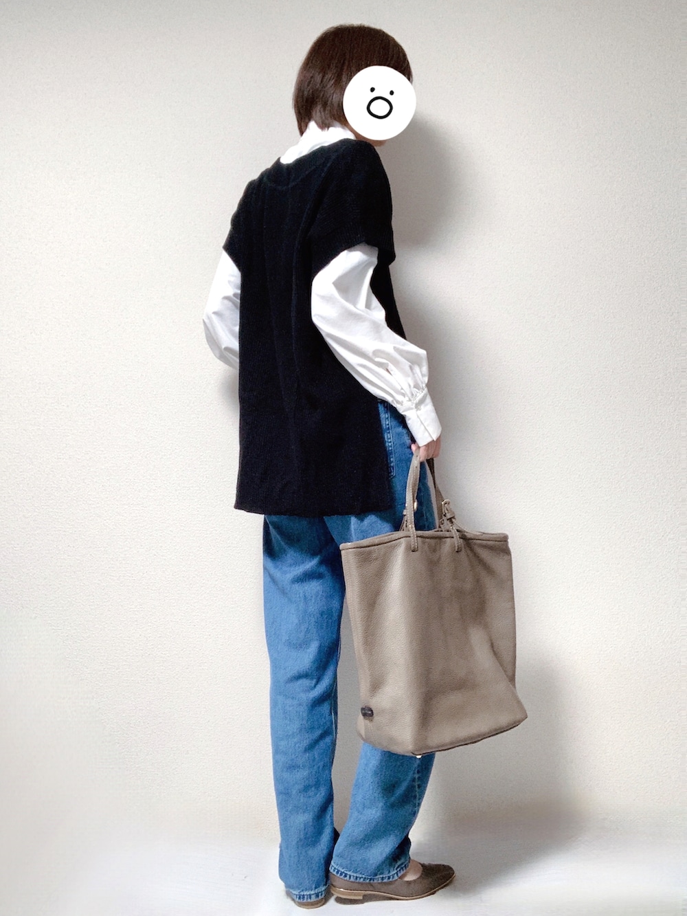 ブラウン系のパンプス、ブルー系のデニムパンツ、ブラウン系のトートバッグを着用したレディースの秋コーディネートの2枚目の写真