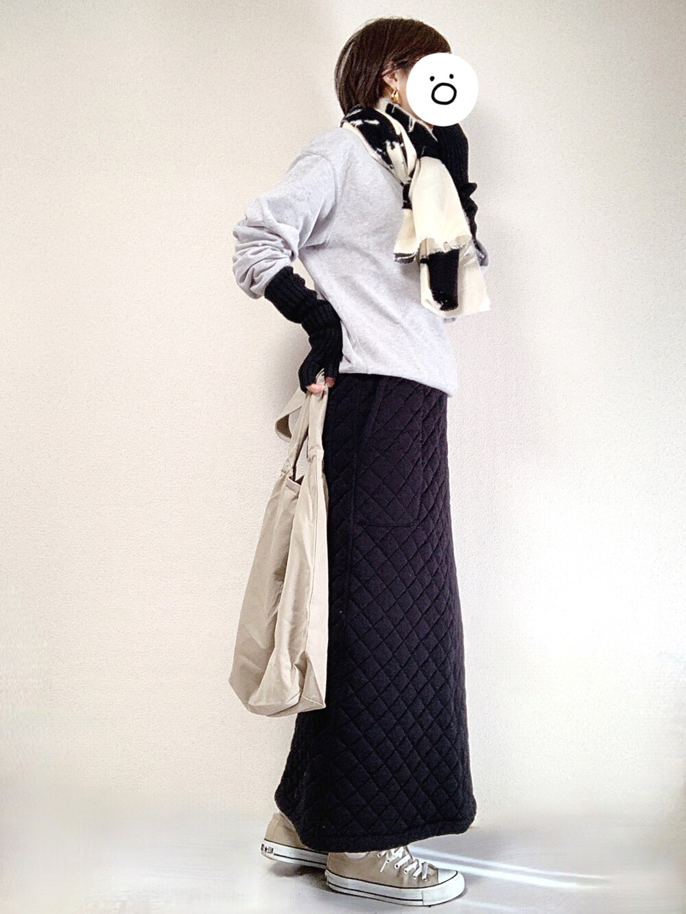 ベージュ系のスニーカー、グレー系のスウェット、ブラック系のスカートを着用したレディースの冬コーディネートの2枚目の写真