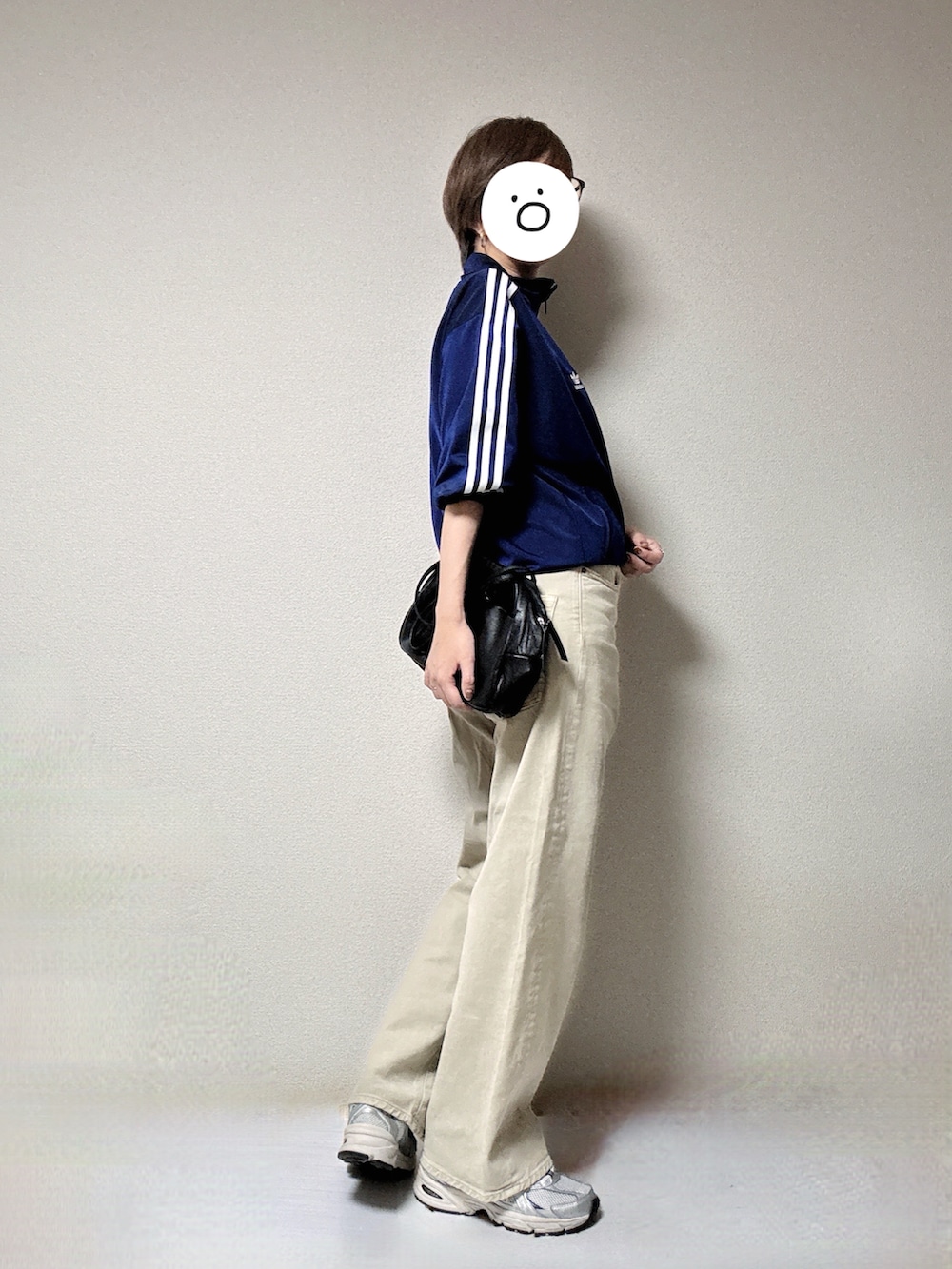 ホワイト系のスニーカー、ブルー系のジャージ、ベージュ系のデニムパンツを着用したレディースの秋コーディネートの2枚目の写真