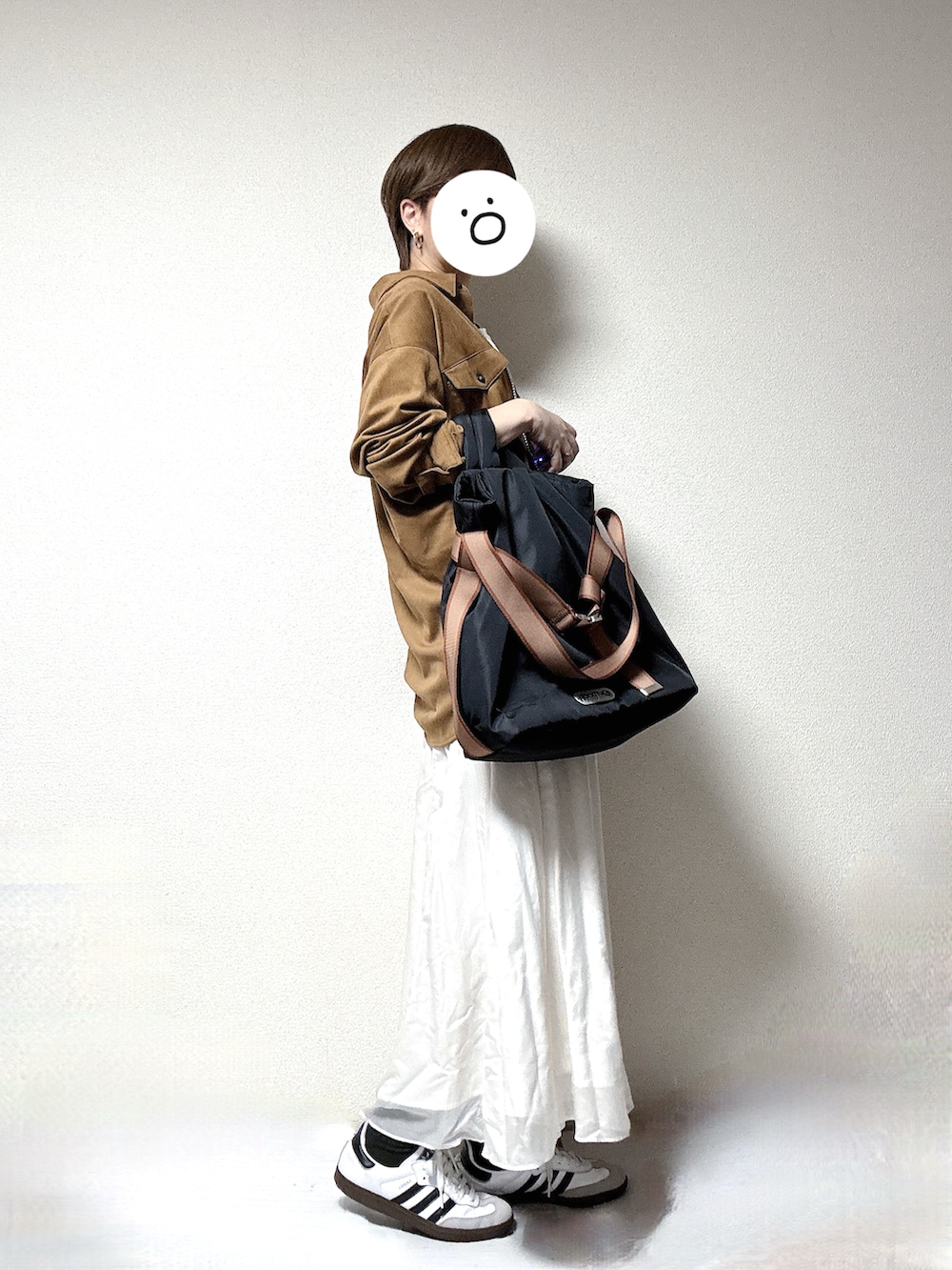 ホワイト系のスニーカー、ベージュ系のシャツ/ブラウス、ホワイト系のスカートを着用したレディースの春コーディネートの2枚目の写真