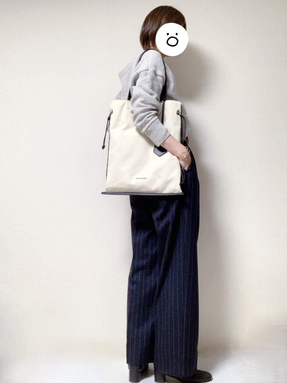 ブラック系のブーツ、ブラック系のトートバッグ、ブルー系のスラックスを着用したレディースの冬コーディネートの3枚目の写真