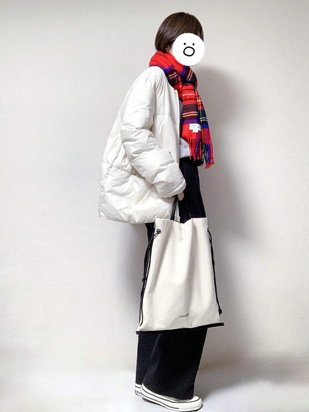 ホワイト系のスニーカー、ブラック系のスラックス、ブラック系のトートバッグを着用したレディースの冬コーディネートの2枚目の写真