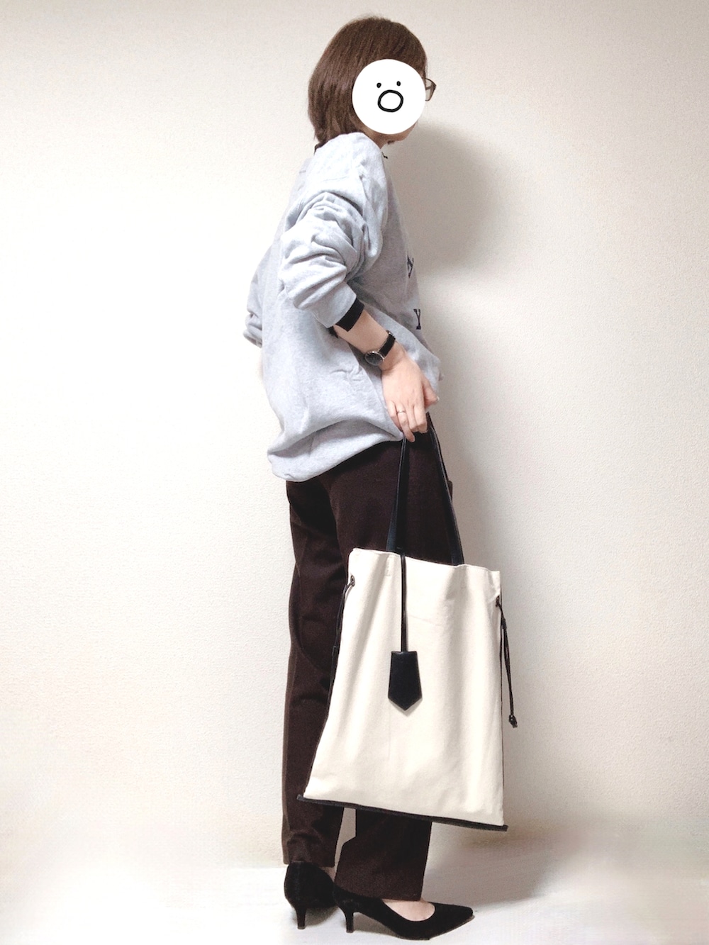 ブラック系のパンプス、ブラック系のトートバッグ、ブラウン系のスラックスを着用したレディースの秋コーディネートの2枚目の写真