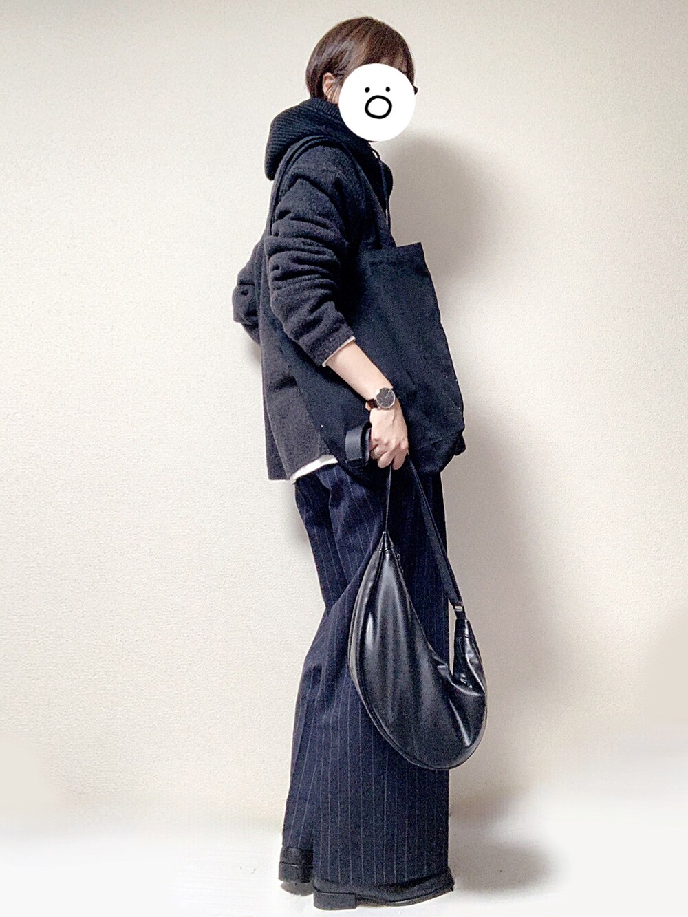 ブラック系のブーツ、ブルー系のスラックス、ブラック系のショルダーバッグを着用したレディースの秋コーディネートの2枚目の写真