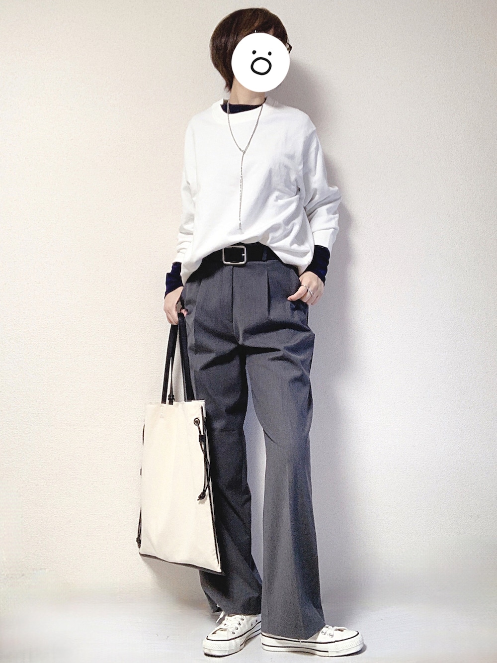 ブラック系のトートバッグ、ホワイト系のスニーカー、グレー系のスラックスを着用したレディースの秋コーディネートの2枚目の写真