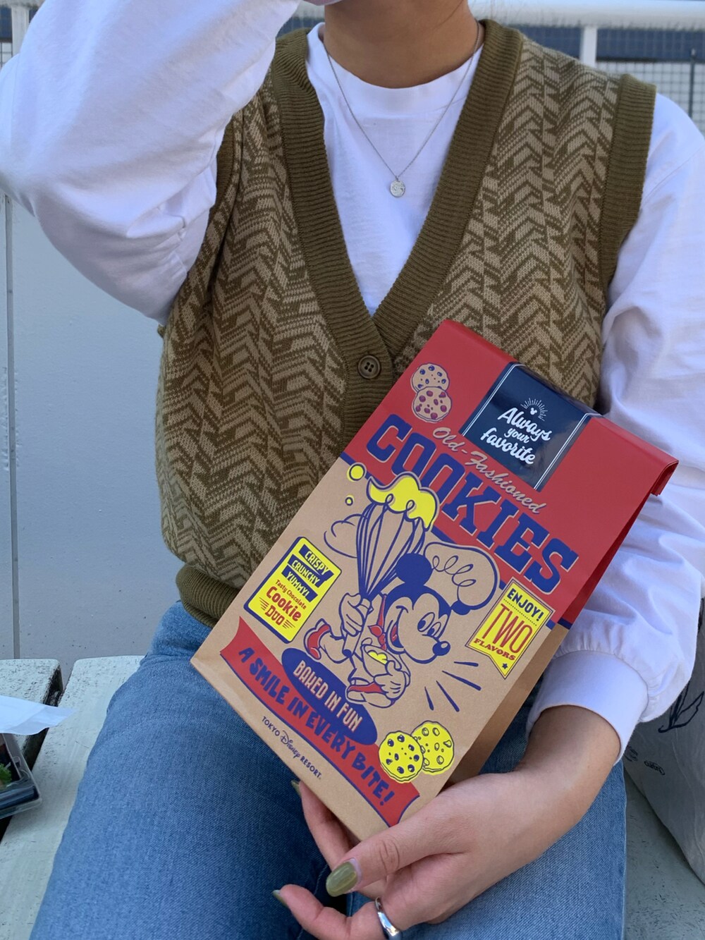 ブルー系のデニムパンツ、ホワイト系のTシャツ/カットソー、グリーン系のベストを着用したレディースの秋コーディネートの2枚目の写真