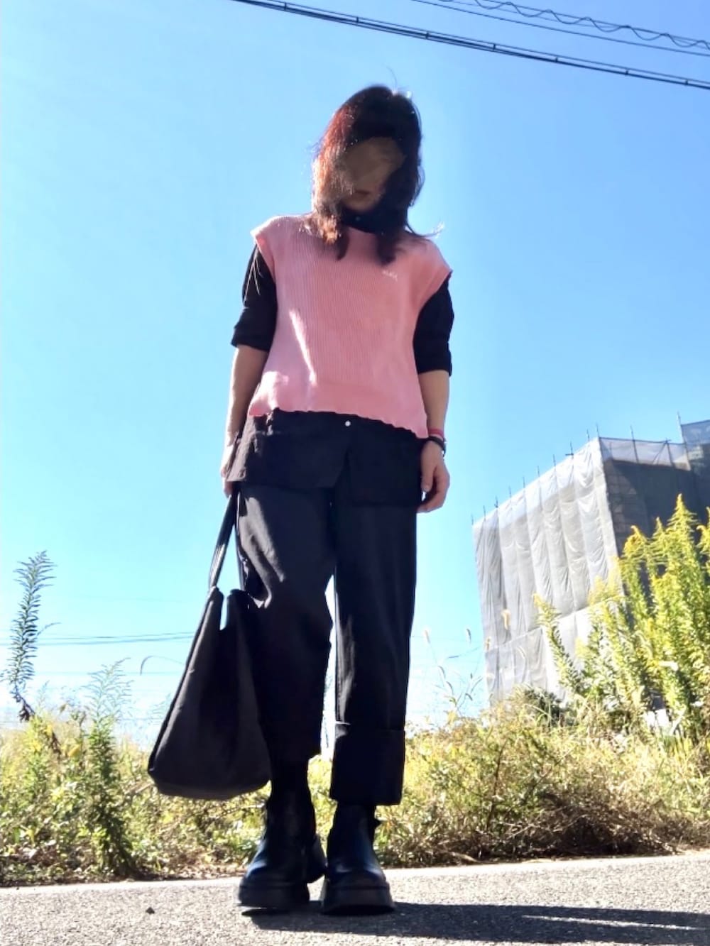 ブラック系のシャツ/ブラウス、ピンク系のベスト、ブラック系のパンツを着用したレディースの秋コーディネートの3枚目の写真