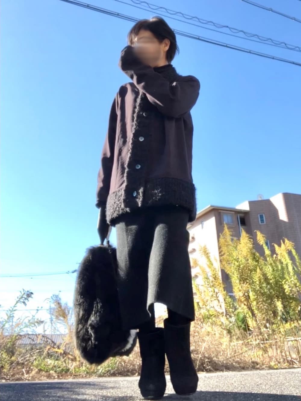 ブラック系のカーディガン/ボレロ、ブラック系のトートバッグを着用したレディースの冬コーディネートの2枚目の写真