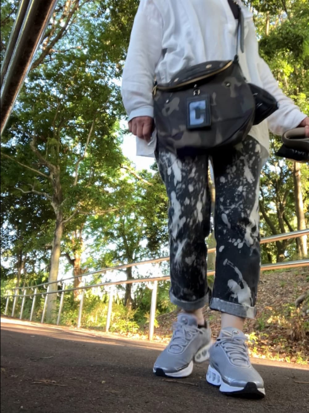 ホワイト系のシャツ/ブラウス、ブラック系のデニムパンツ、シルバー系のスニーカーを着用したレディースの春コーディネートの5枚目の写真