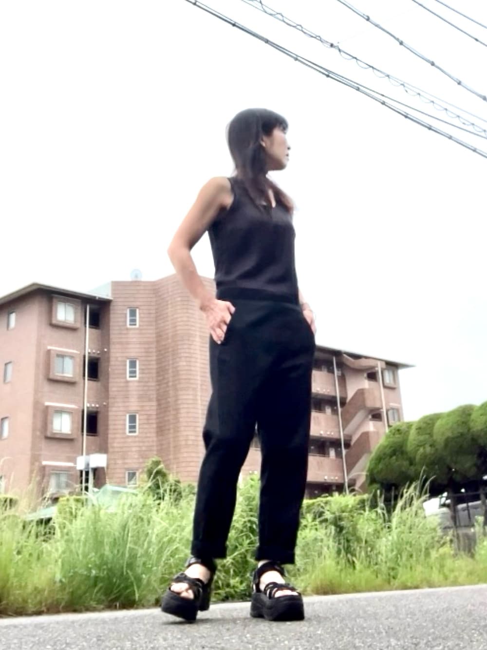 ブラック系のつなぎ/オールインワン、ブラック系のカーディガン/ボレロ、ブラック系のサンダルを着用したレディースの夏コーディネートの3枚目の写真
