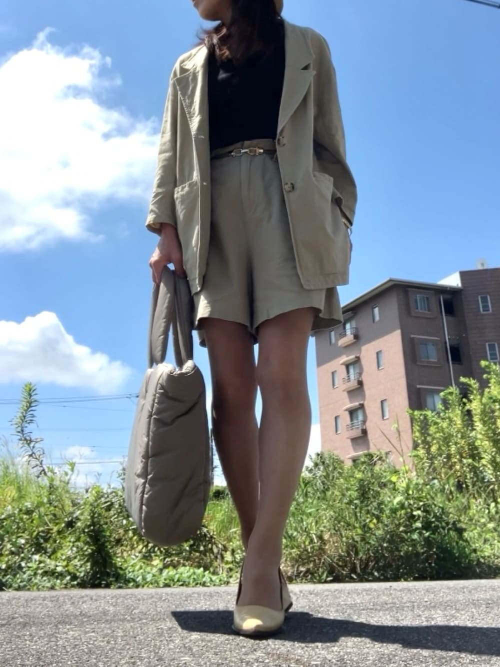 ベージュ系のテーラードジャケット、ベージュ系のパンツ、ブラック系のタンクトップを着用したレディースの夏コーディネートの4枚目の写真