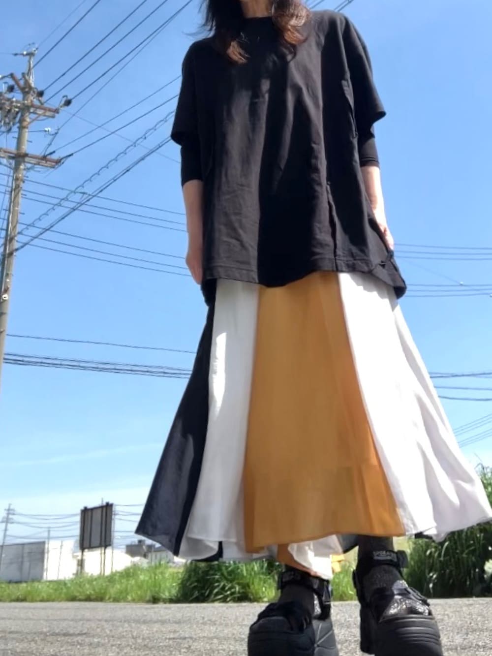 ブラック系のTシャツ/カットソー、その他のスカート、ブラック系のサンダルを着用したレディースの春コーディネートの4枚目の写真