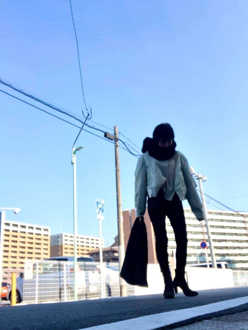 グリーン系のスウェット、ブラック系のパンツ、グレー系のブーツを着用したレディースの冬コーディネートの4枚目の写真