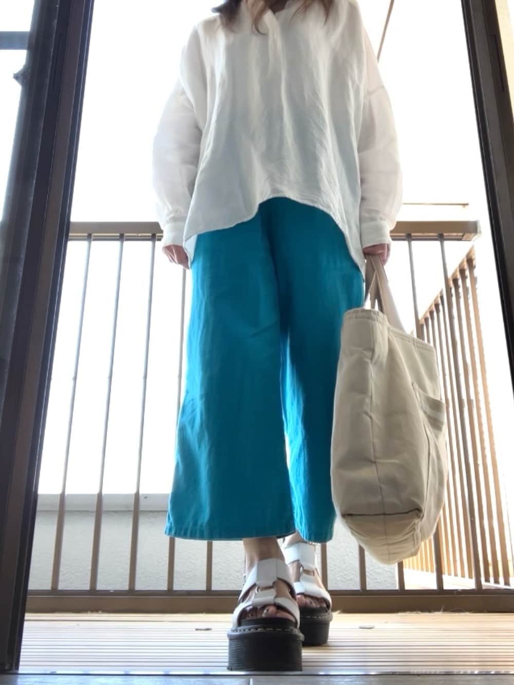 ホワイト系のシャツ/ブラウス、ブルー系のパンツ、ホワイト系のサンダルを着用したレディースの夏コーディネートの4枚目の写真