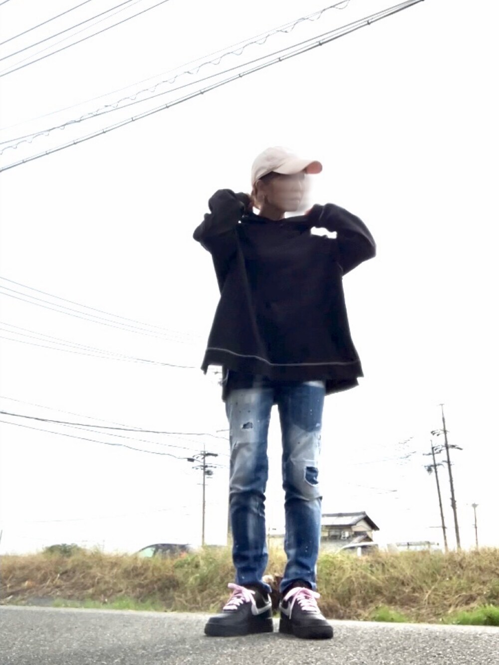 ブラック系のパーカー、ブルー系のデニムパンツ、ブラック系のスニーカーを着用したレディースの秋コーディネートの2枚目の写真