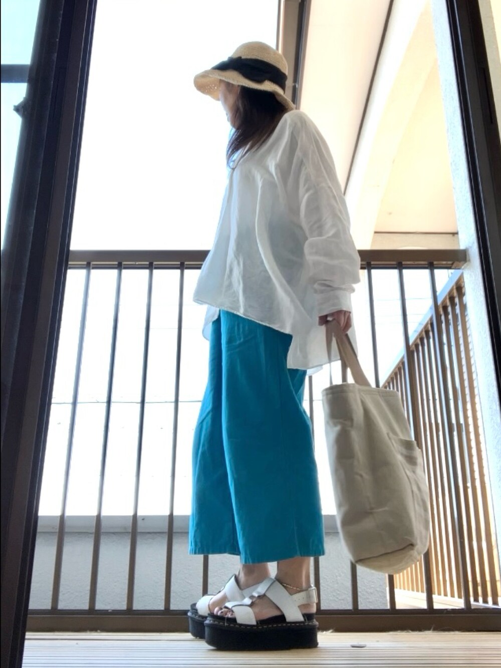 ホワイト系のシャツ/ブラウス、ブルー系のパンツ、ホワイト系のサンダルを着用したレディースの夏コーディネートの3枚目の写真