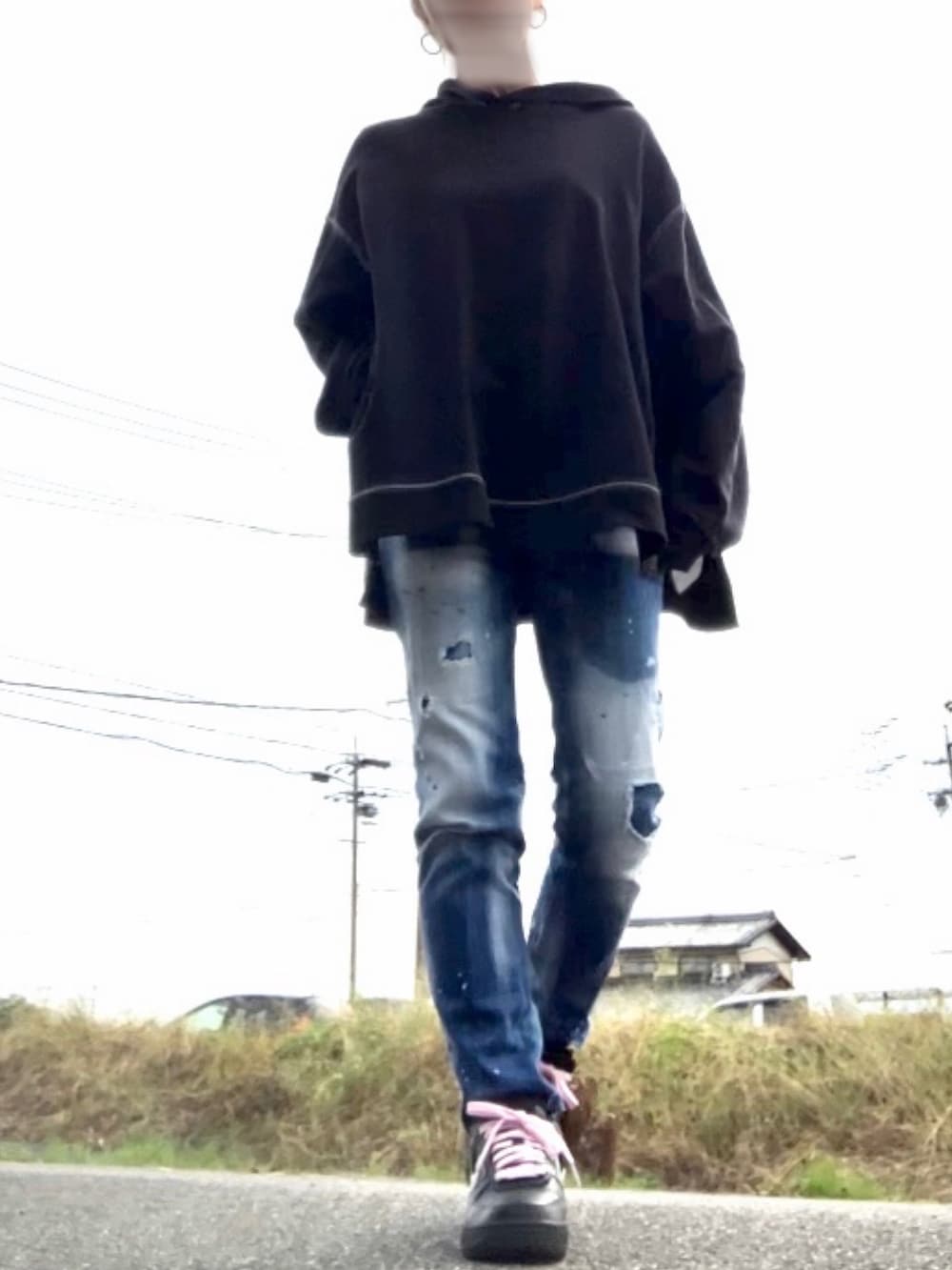 ブラック系のパーカー、ブルー系のデニムパンツ、ブラック系のスニーカーを着用したレディースの秋コーディネートの4枚目の写真