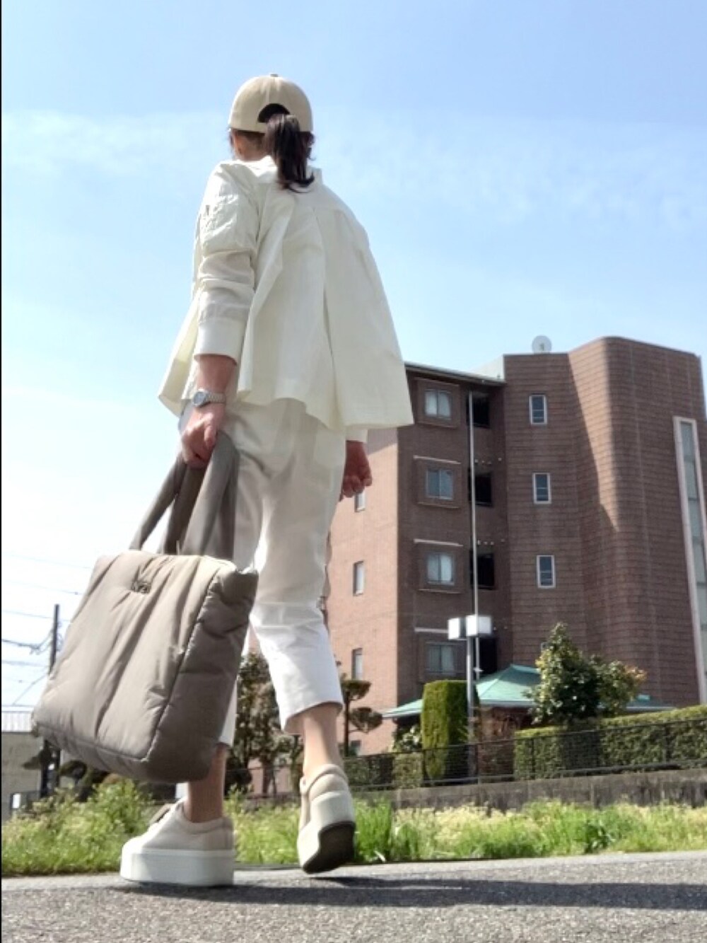 ホワイト系のMA-1、ホワイト系のTシャツ/カットソー、ホワイト系のパンツを着用したレディースの春コーディネートの2枚目の写真