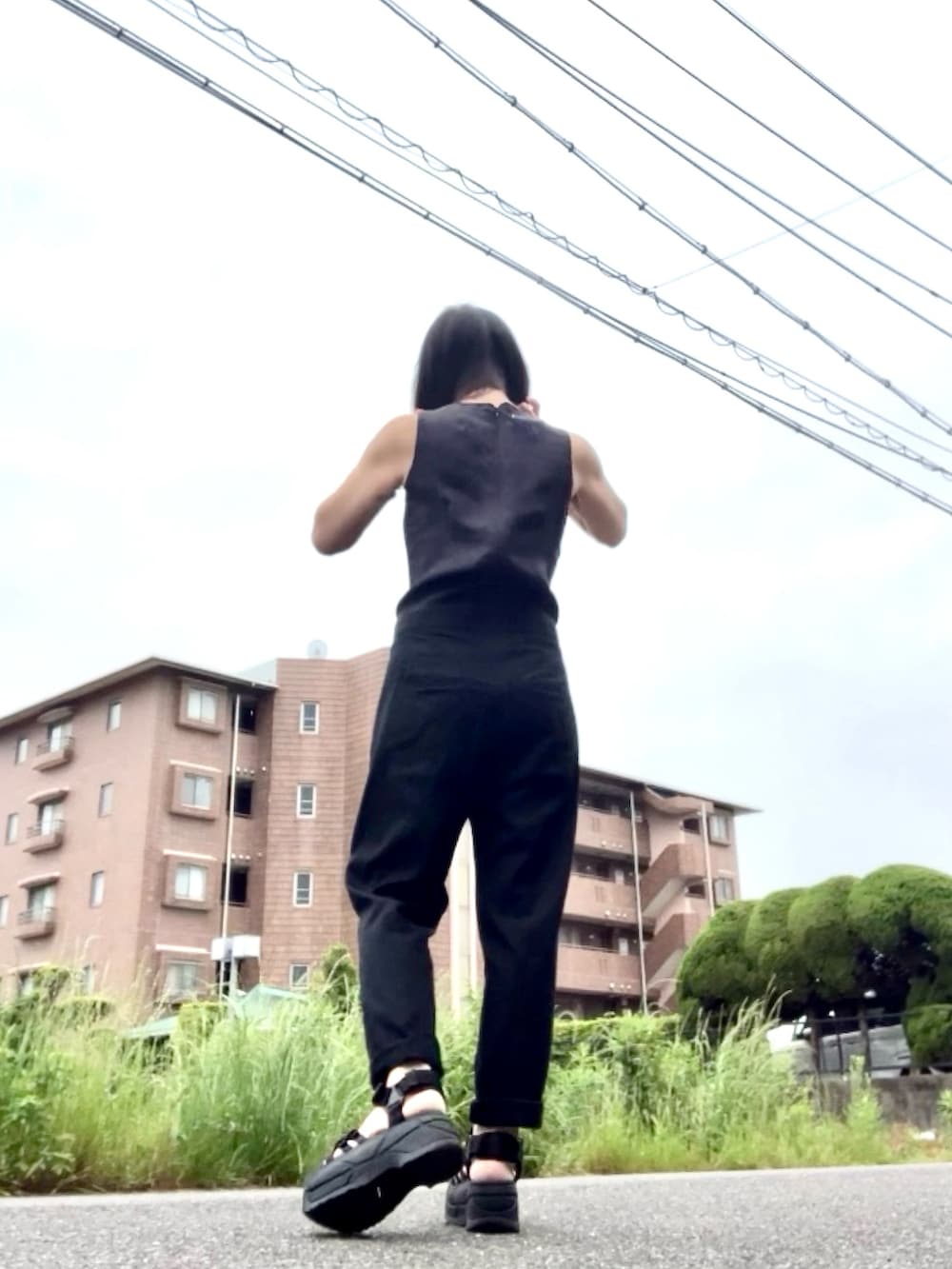 ブラック系のつなぎ/オールインワン、ブラック系のカーディガン/ボレロ、ブラック系のサンダルを着用したレディースの夏コーディネートの4枚目の写真