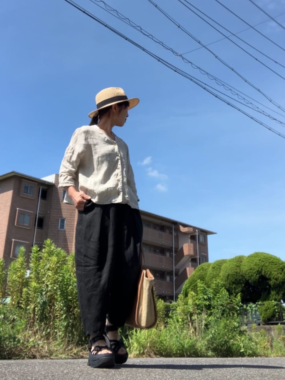 ベージュ系のシャツ/ブラウス、ブラック系のパンツ、ブラック系のサンダルを着用したレディースの夏コーディネートの2枚目の写真