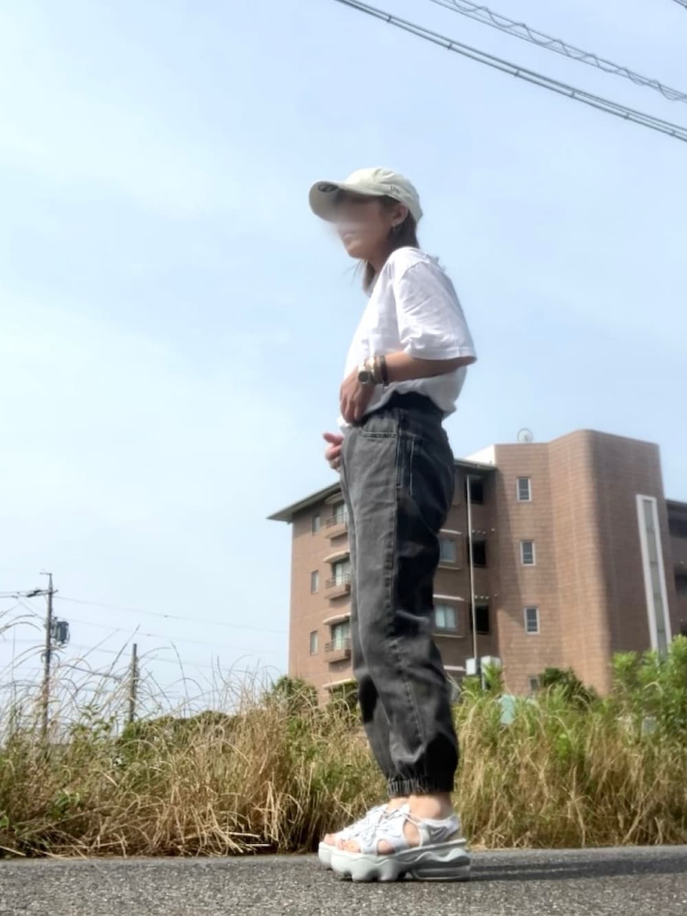 ホワイト系のTシャツ/カットソー、シルバー系のサンダル、ブラック系のデニムパンツを着用したレディースの夏コーディネートの2枚目の写真