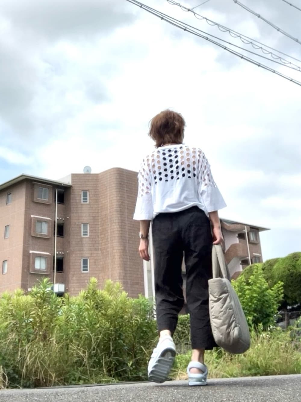 ブルー系のサンダル、ホワイト系のTシャツ/カットソー、ブラック系のサロペット/オーバーオールを着用したレディースの夏コーディネートの3枚目の写真
