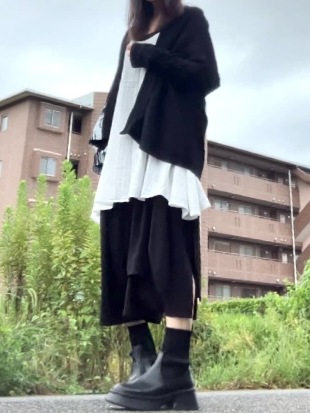 ブラック系のカーディガン/ボレロ、ブラック系のパンツ、ブラック系のブーツを着用したレディースの秋コーディネートの5枚目の写真