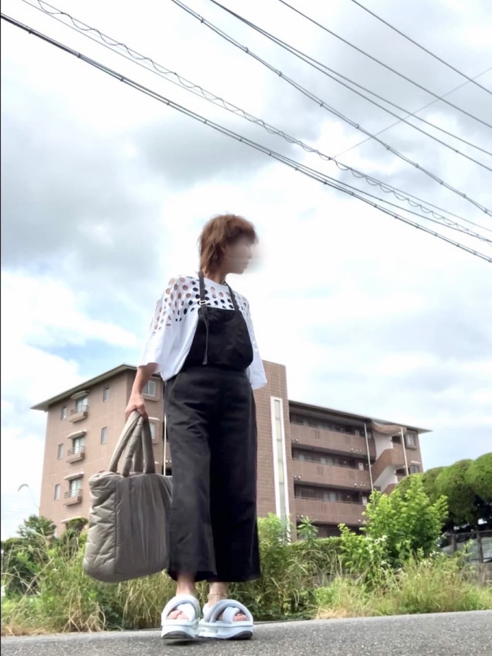 ブルー系のサンダル、ホワイト系のTシャツ/カットソー、ブラック系のサロペット/オーバーオールを着用したレディースの夏コーディネートの2枚目の写真