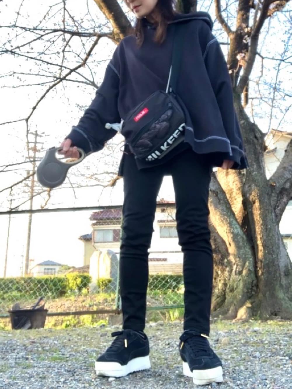 ブラック系のパーカー、ブルー系のTシャツ/カットソー、ブラック系のデニムパンツを着用したレディースの春コーディネートの5枚目の写真