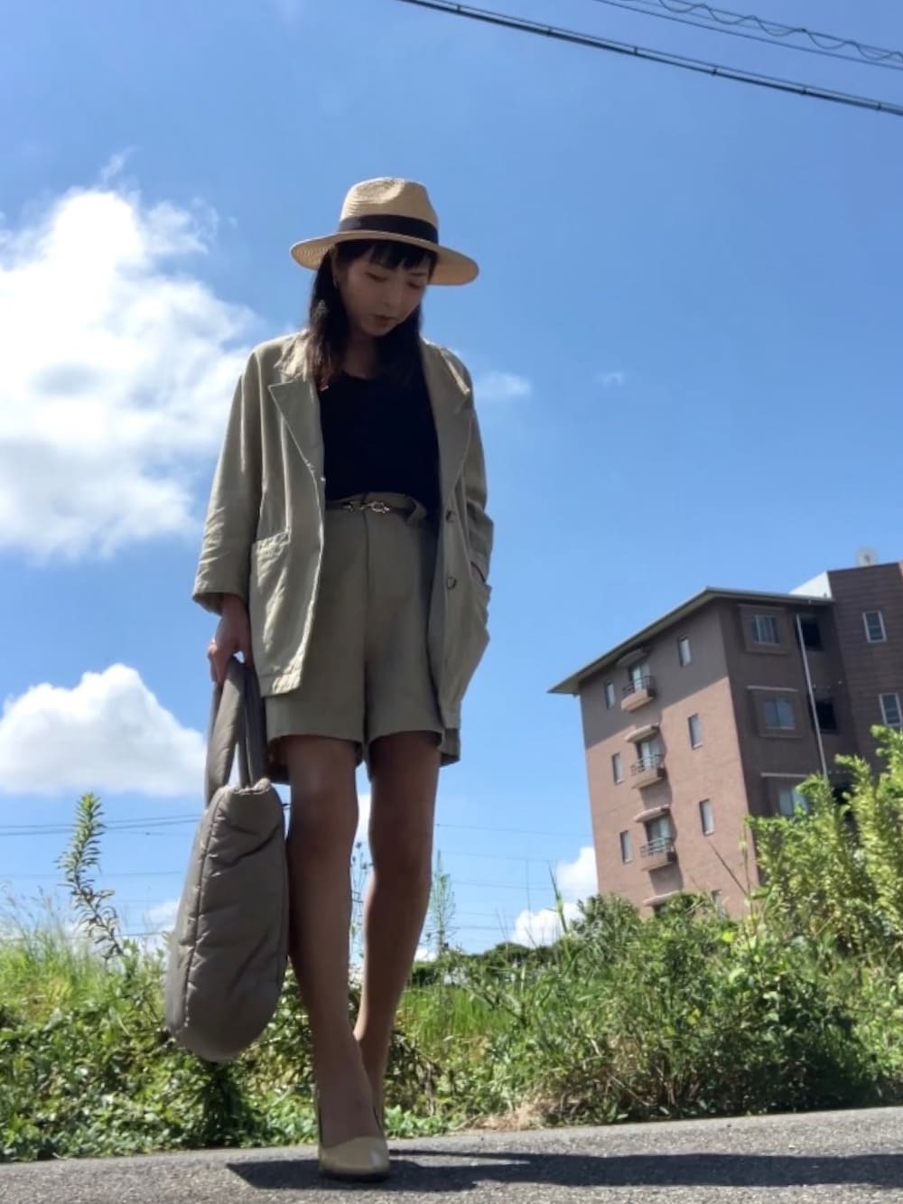 ベージュ系のテーラードジャケット、ベージュ系のパンツ、ブラック系のタンクトップを着用したレディースの夏コーディネートの3枚目の写真