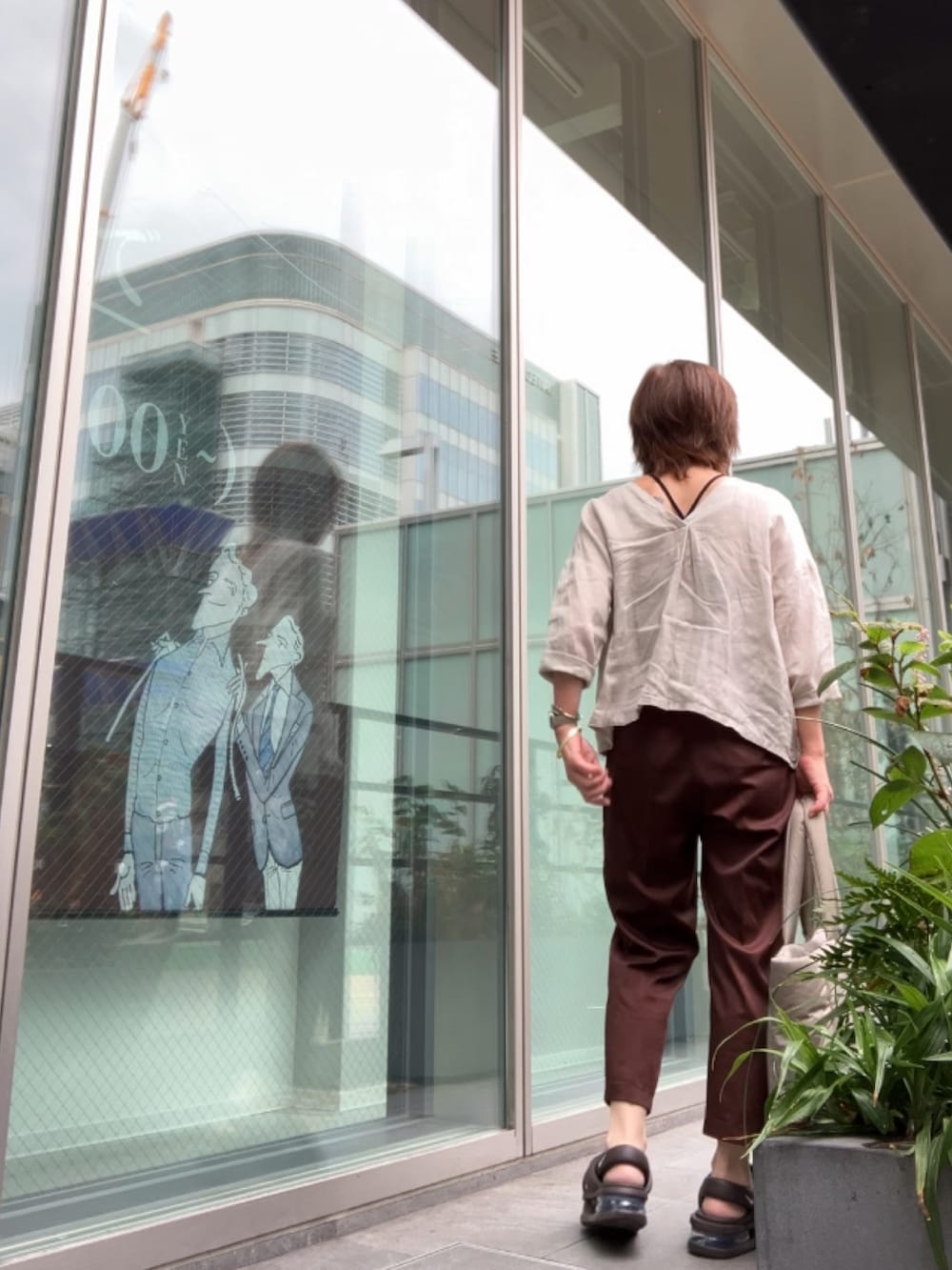 ブラウン系のサンダル、ベージュ系のシャツ/ブラウス、ブラウン系のパンツを着用したレディースの秋コーディネートの3枚目の写真