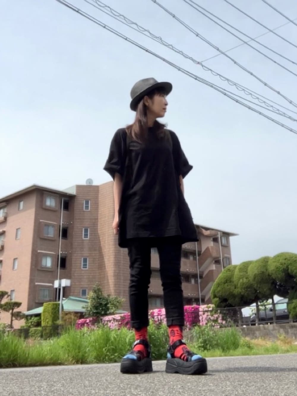 ブラック系のTシャツ/カットソー、ブラック系のデニムパンツ、ブラック系のサンダルを着用したレディースの春コーディネートの2枚目の写真