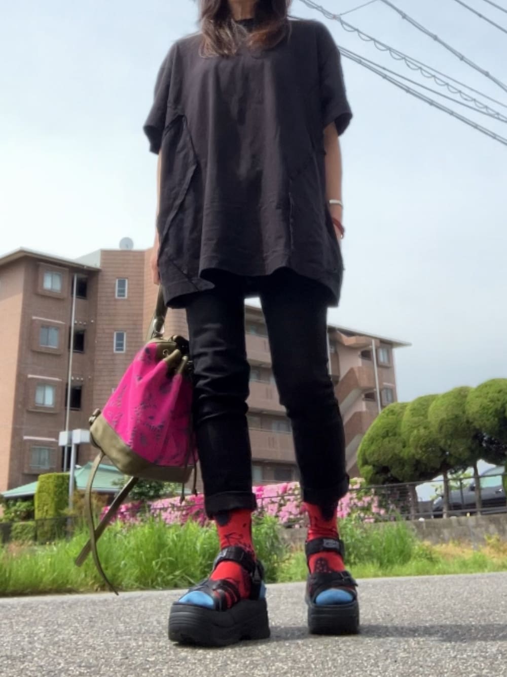 ブラック系のTシャツ/カットソー、ブラック系のデニムパンツ、ブラック系のサンダルを着用したレディースの春コーディネートの4枚目の写真