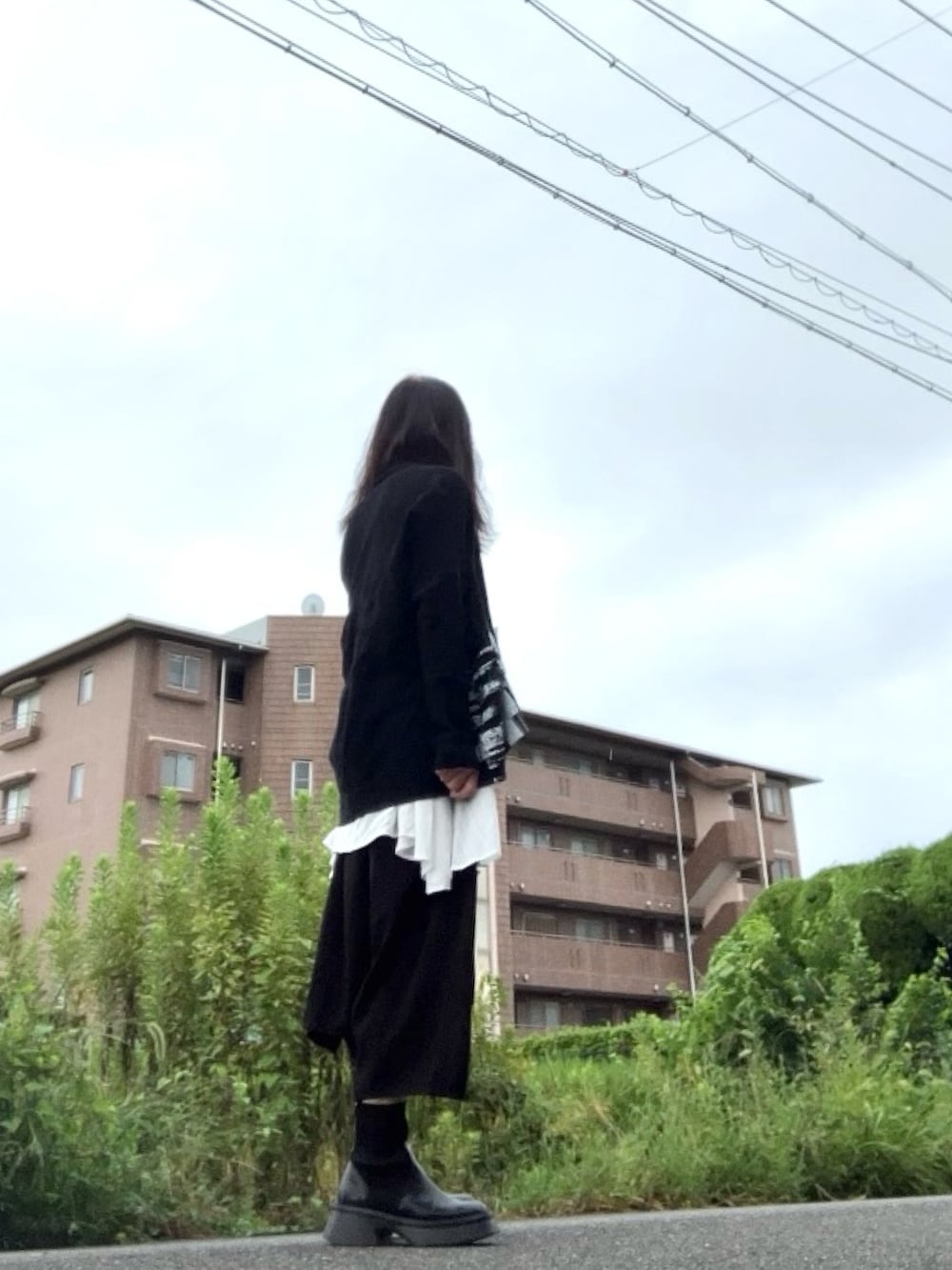 ブラック系のカーディガン/ボレロ、ブラック系のパンツ、ブラック系のブーツを着用したレディースの秋コーディネートの3枚目の写真