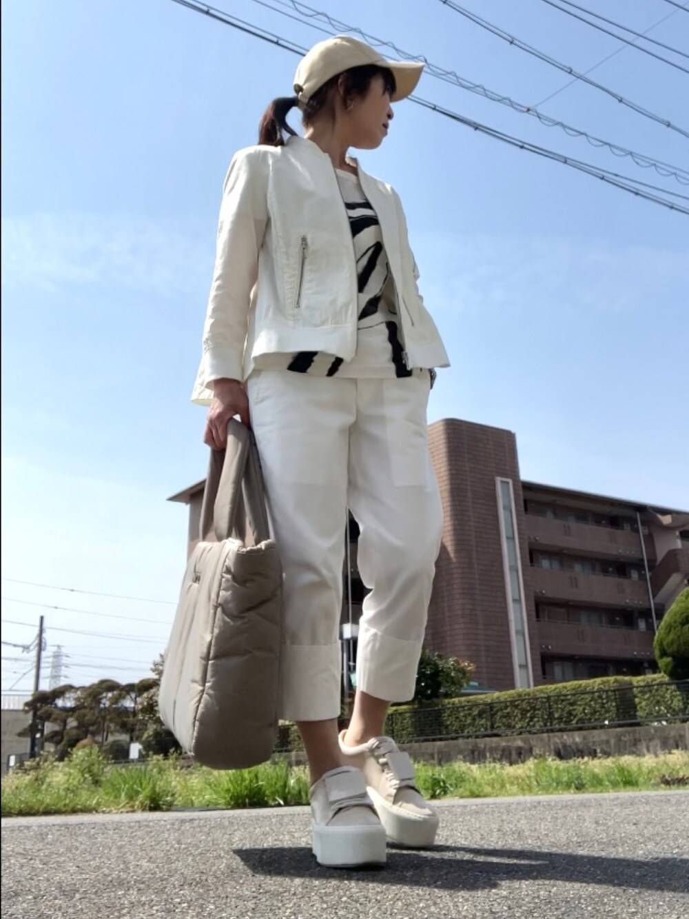 ホワイト系のMA-1、ホワイト系のTシャツ/カットソー、ホワイト系のパンツを着用したレディースの春コーディネートの3枚目の写真