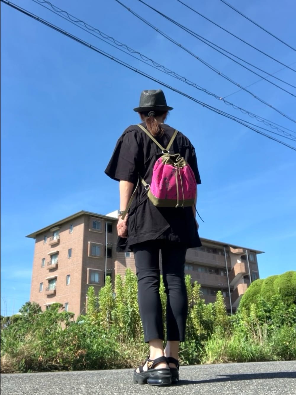ブラック系のTシャツ/カットソー、ピンク系のバックパック/リュック、ブラック系のパンツを着用したレディースの夏コーディネートの3枚目の写真
