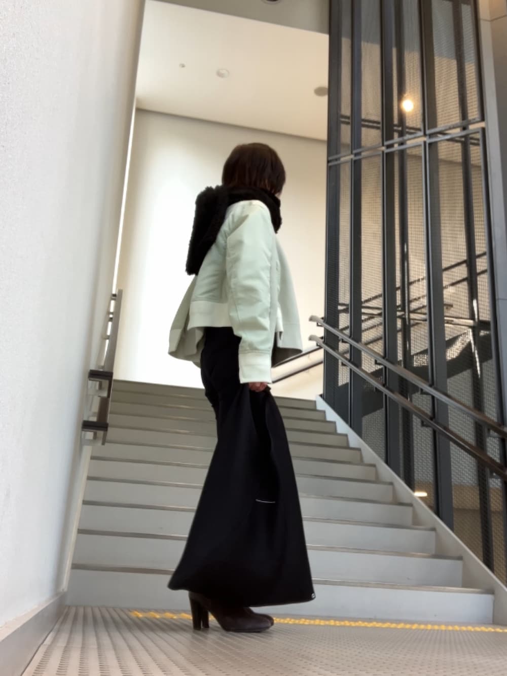 グリーン系のスウェット、ブラック系のパンツ、グレー系のブーツを着用したレディースの冬コーディネートの2枚目の写真