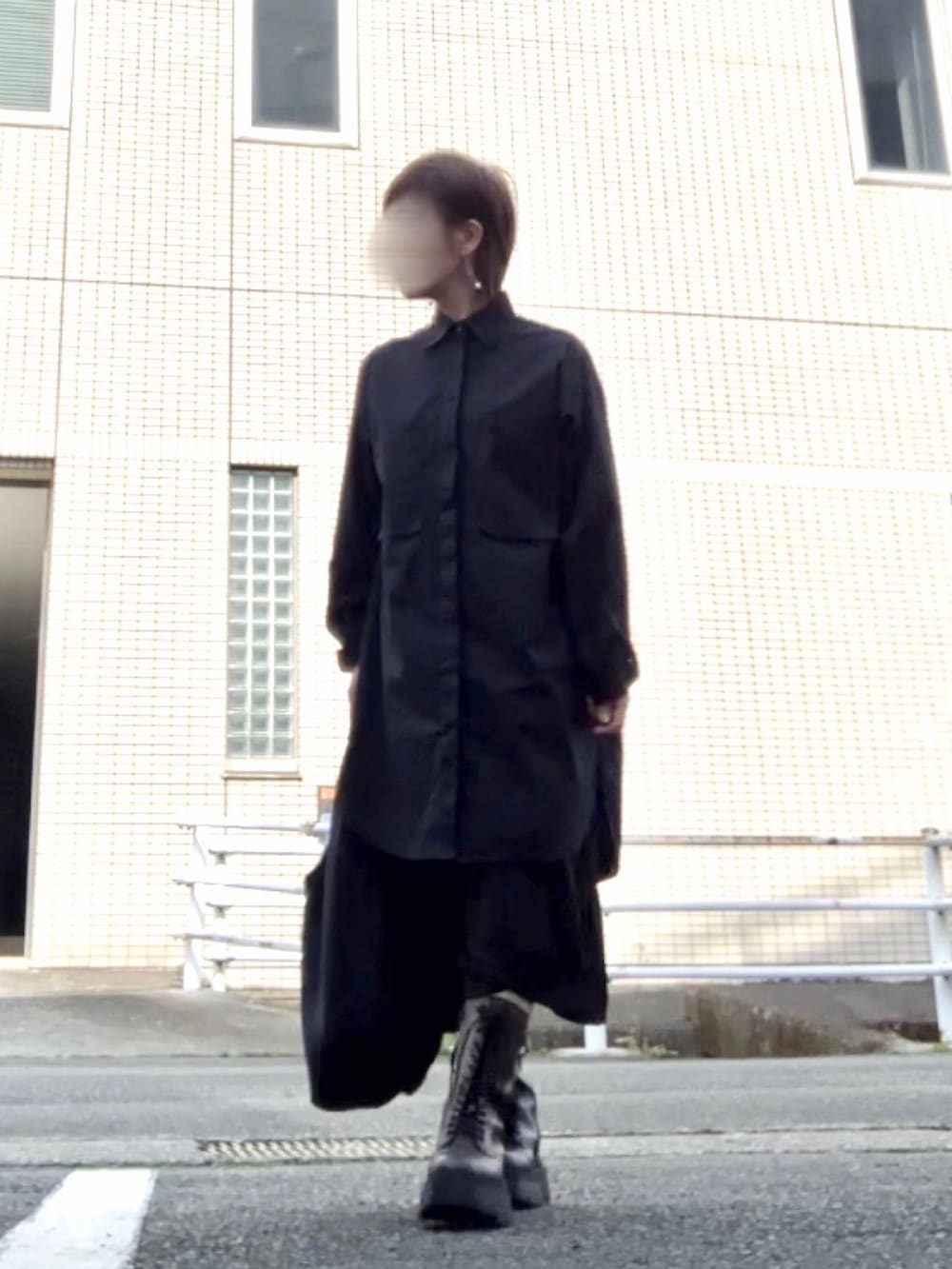 ブラック系のシャツ/ブラウス、ブラック系のパンツ、ブラウン系のブーツを着用したレディースの春コーディネートの2枚目の写真